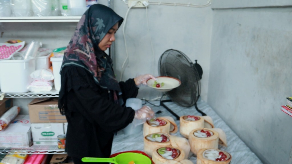 MENU UNIK: Owner UMKM Lica Lecy Pudding, Afila Hardiyanti menyajikan menu es krim batok kelapa untuk pembeli, belum lama ini.