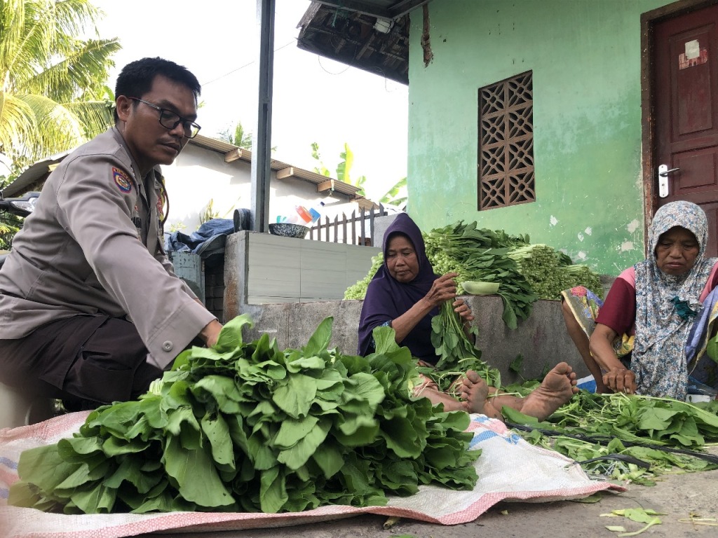 JEMPUT PESANAN: Aiptu Suryawan yang tengah menjemput pesanan sayuran dari konsumen di salah satu pedagang sayur di Desa Jembatan Kembar, Lombok Barat, belum lama ini.