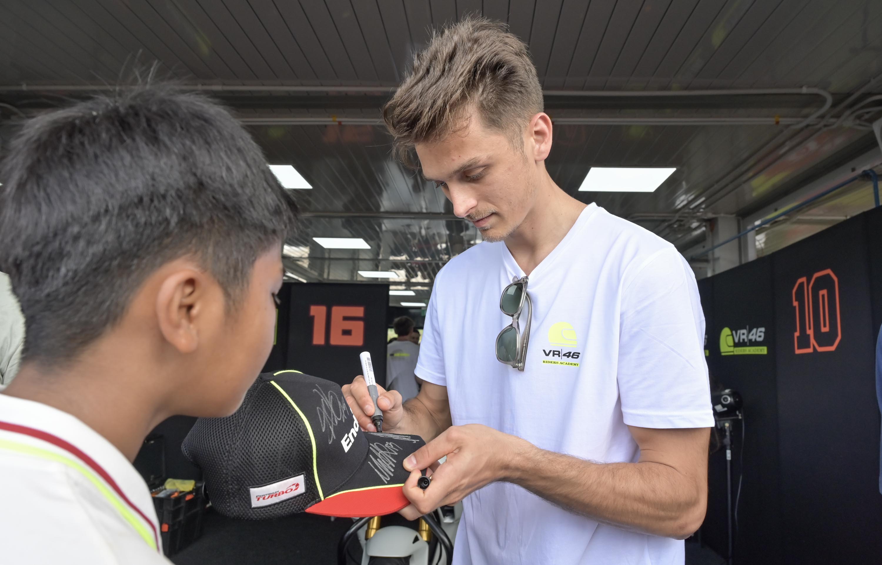 Pembalap MotoGP Luca Marini memberikan tanda tangan kepada penggemar di Paddock Sirkuit Internasional Mandalika sebelum rangkaian Track Day Pertamina VR46 Academy, Senin (27/1).