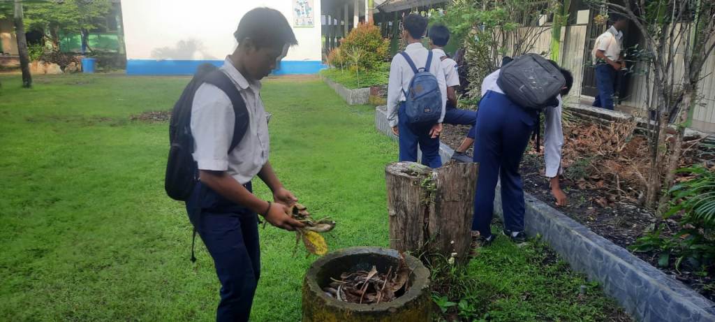 JAGA LINGKUNGAN: Siswa SMPN 10 Mataram memungut daun yang berserakan di halaman sekolah setempat, belum lama ini.