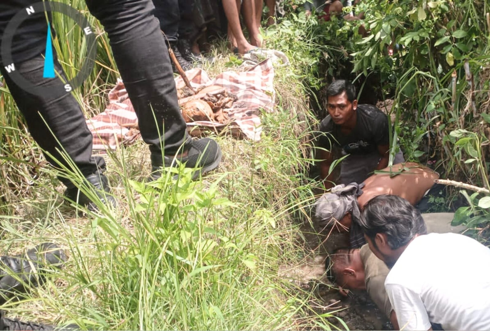 EVAKUASI: Tim Inafis bersama warga Desa Pohgading saat mengevakuasi tengkorak manusia yang ditemukan di sebuah parit sawah.