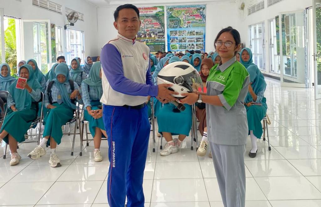 F-img&mdash;Peduli keselamatan : instruktur safety riding Astra Motor NTB saat memberikan helm SNI.