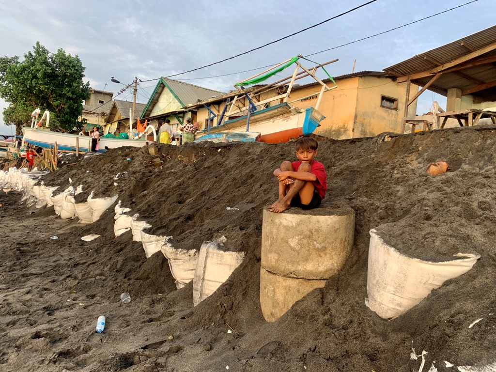DUDUK SANTAI: Seorang anak sedang duduk atas tanggul tepi pantai sisa abrasi di Bintaro, Ampenan, beberapa waktu lalu.&nbsp;