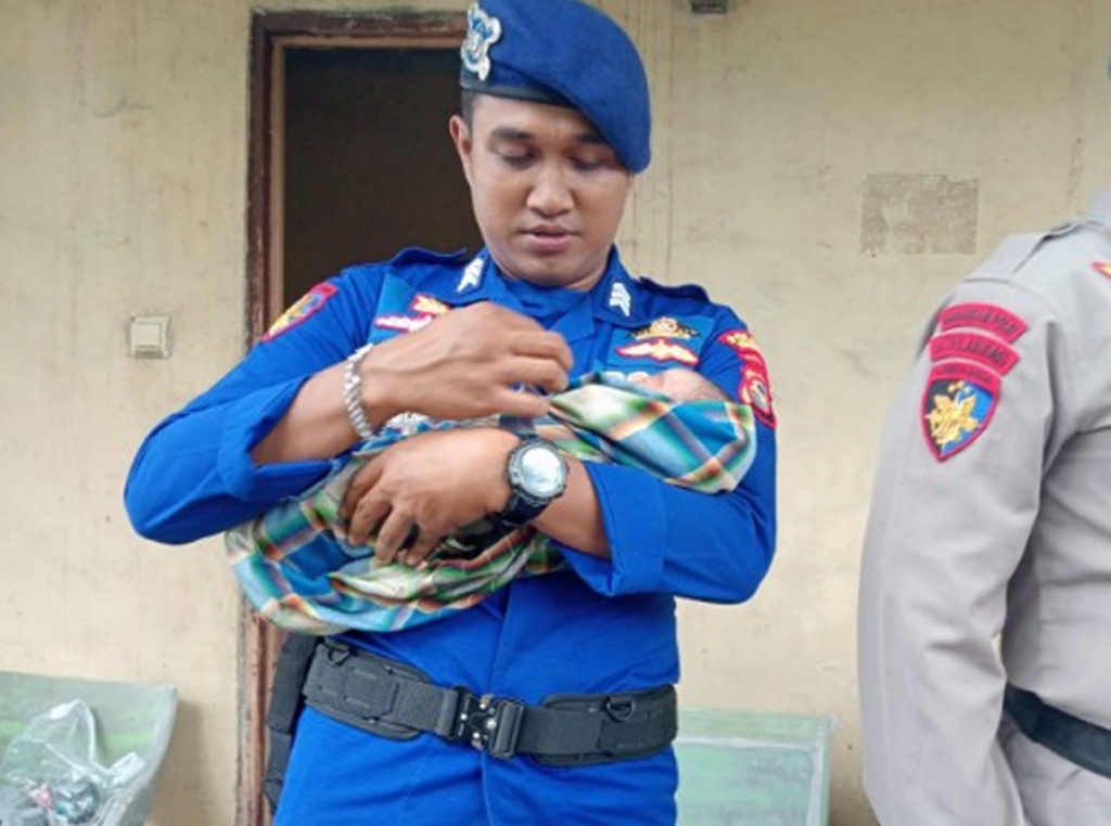 Anggota Satpolairud Polres Sumbawa menggendong bayi perempuan yang ditemukan di semak-semak Desa Labuhan Badas, Senin (3/2).
