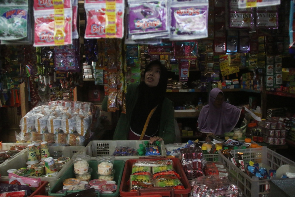 MENUNGGU PEMBELI : Seorang pedagang eceran sedang merapikan dagangannya, beberapa waktu lalu.&nbsp;