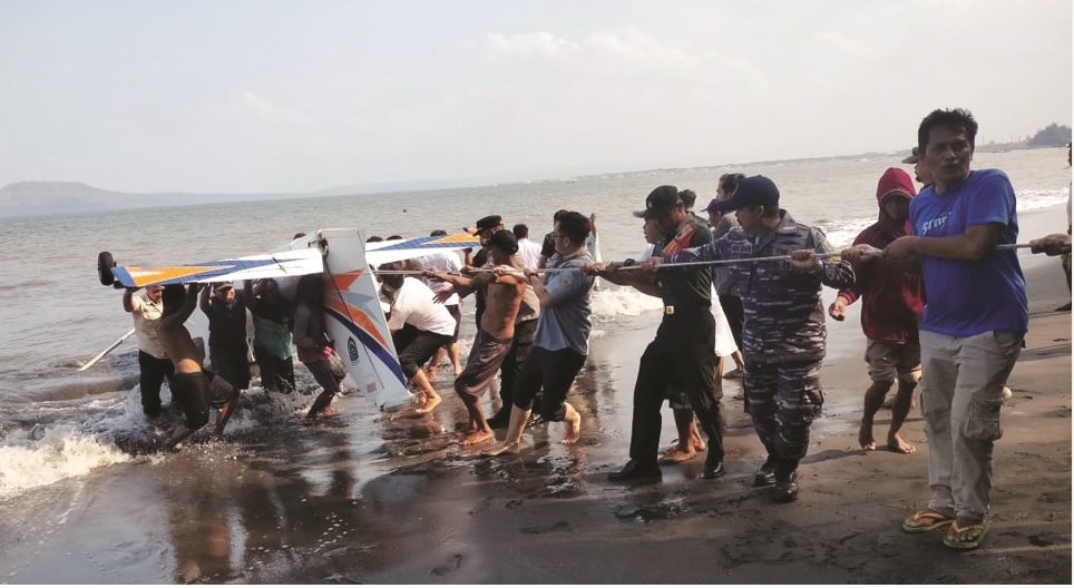 EVAKUASI: Tim Gabungan dibantu warga Mengevakuasi pesawat latih Akademi Penerbangan Indonesia Banyuwangi yang jatuh di Pantai Gumuk Kantong, Banyuwangi, Jawa Timur, Selasa (4/2).