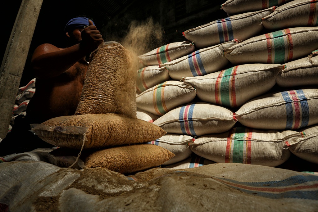 ILUSTRASI: Seorang petani merapikan karung-karung gabah hasil pertanian.