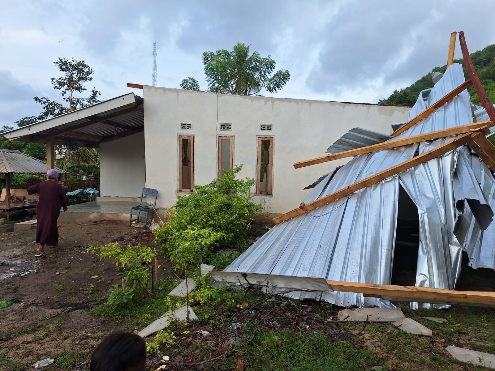Salah satu rumah warga mengalami kerusakan akibat hujan disertai angin kencang, Minggu (9/2).
