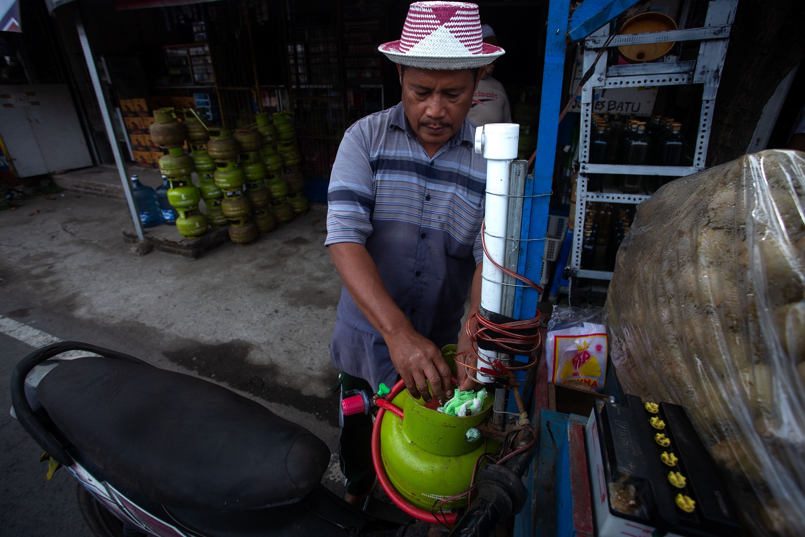 PASANG ELPIJI: Salah satu pelaku usaha mikro yang memasangkan elpiji 3 kg di gerobak jualannya usai membeli di pangkalan resmi, di Mataram.