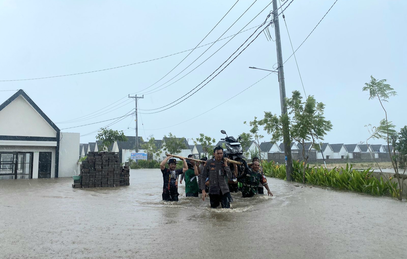 BANTU EVAKUASI WARGA: Personel Polres Lobar saat membantu warga melakukan evakuasi dari banjir yang terjadi di wilayah Kecamatan Labuapi.