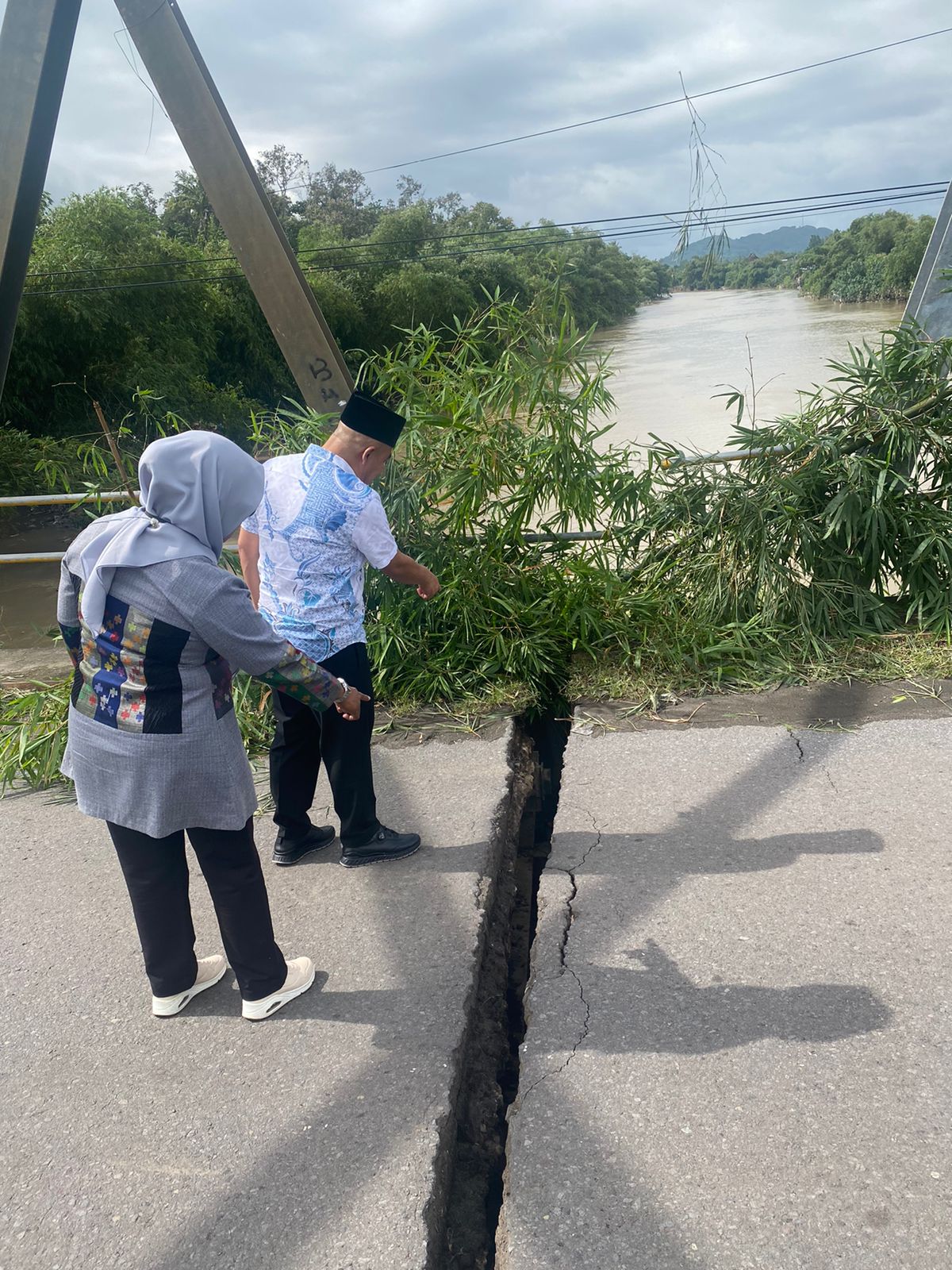 Plt Kadis PUPR NTB Lies Nurkomalasari dan Kadis PUTR Lobar Lalu Winengan menunjukkan kondisi aspal yang retak karena tiang jembatan bawah sungai sudah bergeser.