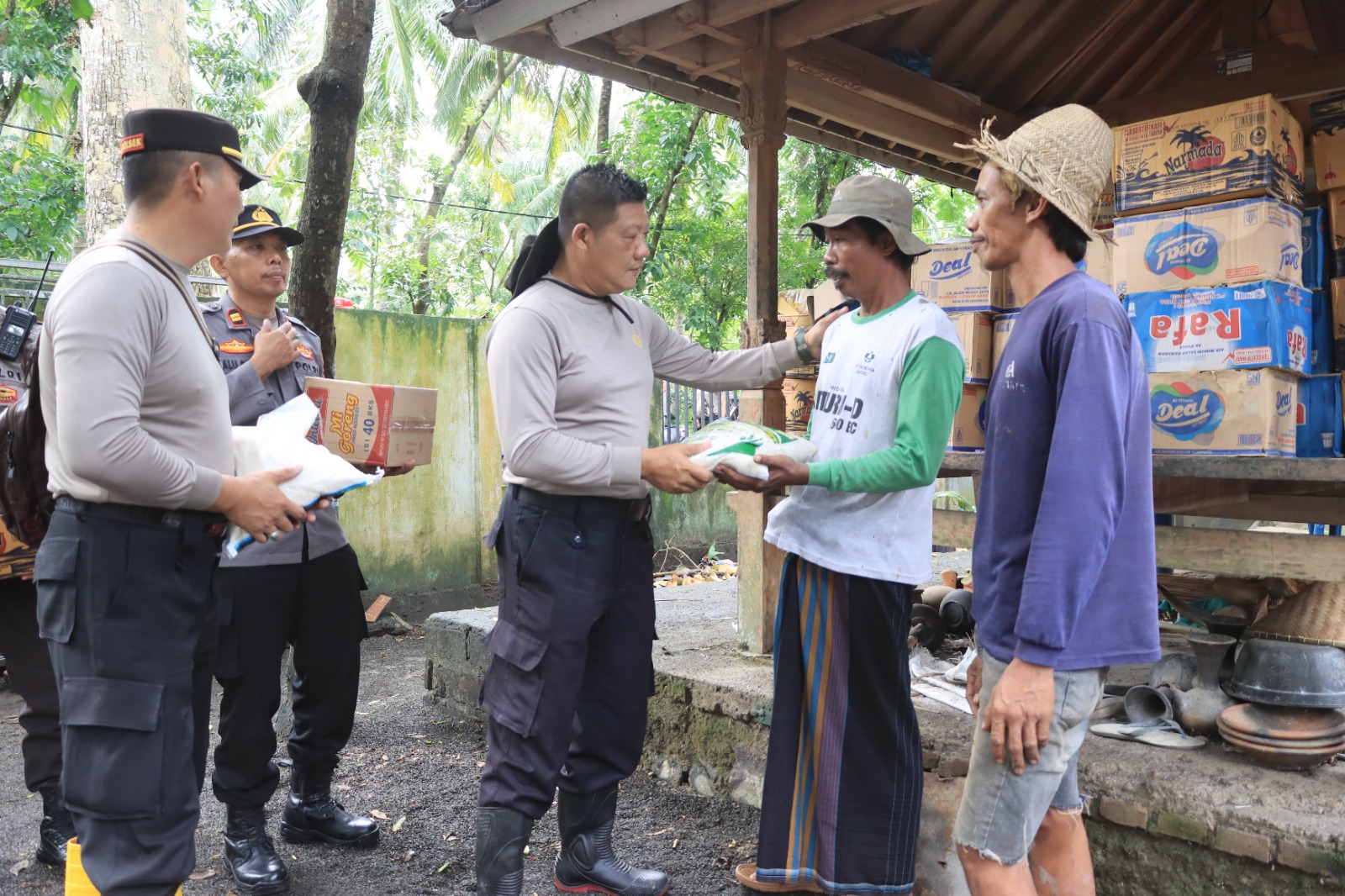 Kabag Ops Polres Loteng AKP Hery Indrayanto secara simbolis memberikan bantuan sosial kepada warga terdampak banjir di Kecamatan Pujut, Jumat (14/2).