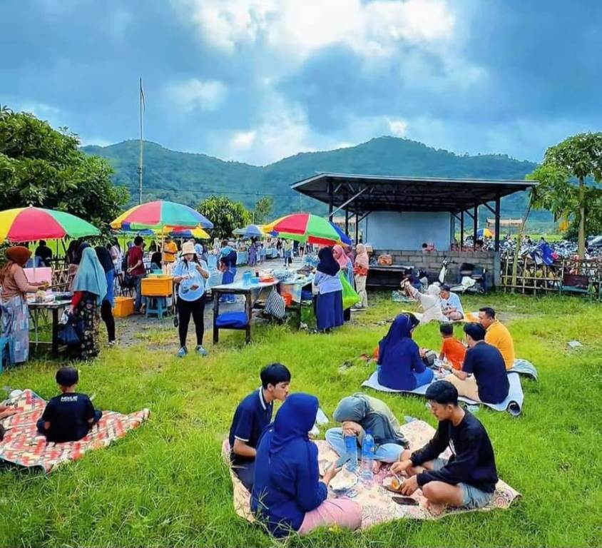 KULINER SAMBIL WISATA: Pengunjung menikmati aneka jajan tradisional Lombok sambil menikmati indahnya pemandangan sawah dan bukit Desa Tempos, Minggu (16/2).