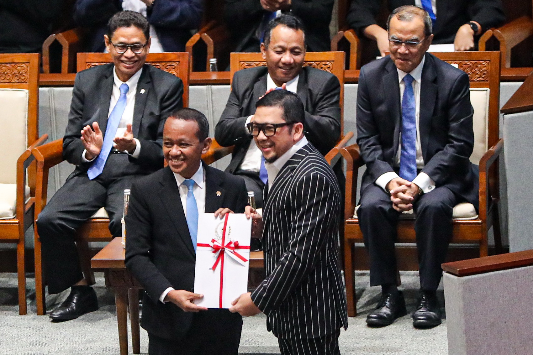 Menteri ESDM Bahlil Lahadalia (kiri) menerima laporan dari Wakil Ketua Badan Legislasi DPR RI Ahmad Doli Kurnia (kanan) saat Rapat Paripurna DPR RI Ke-13 Masa Persidangan II Tahun Sidang 2024-2025 di Kompleks Parlemen, Senayan, Jakarta, Selasa (18/2/2025)