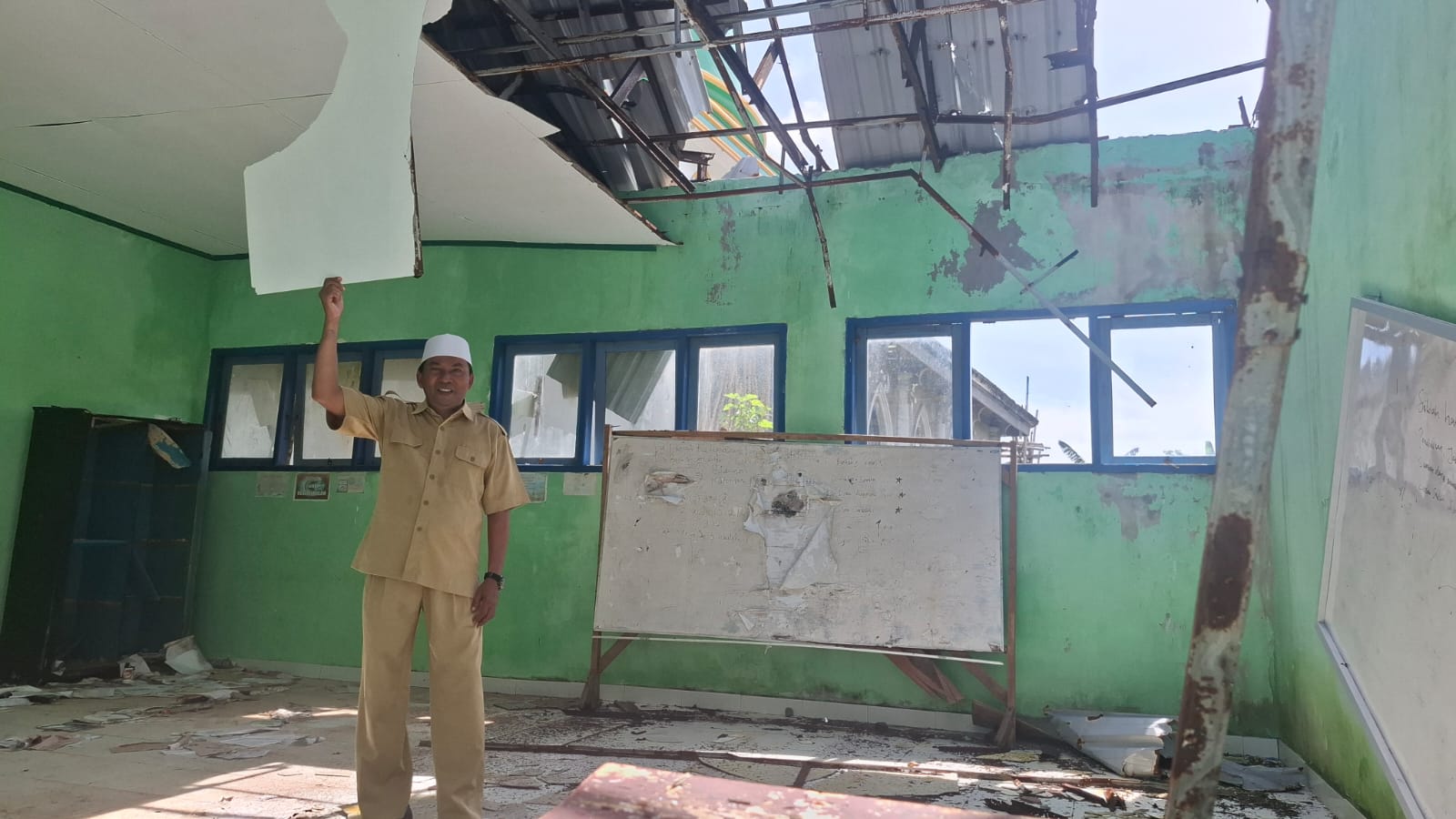 PENDIDIKAN DASAR: Guru SDN 11 Buwun Mas Ruslan menunjukkan kondisi ruang kelas yang rusak berat.