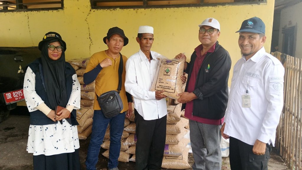 BANTUAN PEMERINTAH: Pemerintah setempat mendistribusikan bibit padi kepada salah satu warga (tiga dari kiri), dimana lahan sawahnya terdampak banjir di Kecamatan Wera.