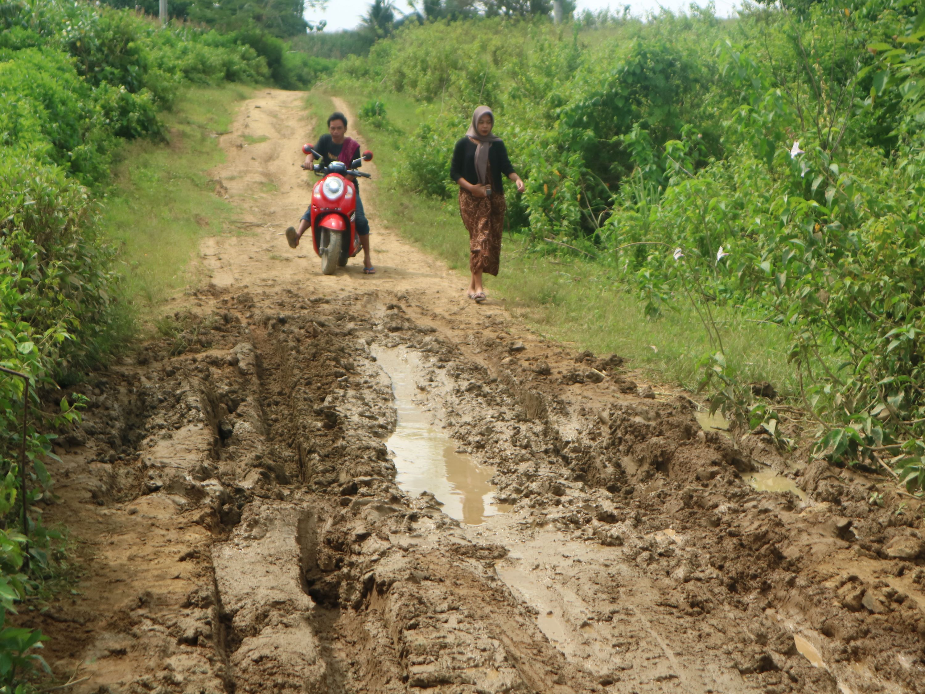 PAKAI DANA DESA: Pengendara motor hendak melintasi jalan rusak di Dusun Pemoles, Desa Batu Jangkih, Kecamatan Praya Barat Daya, Loteng, belum lama ini.