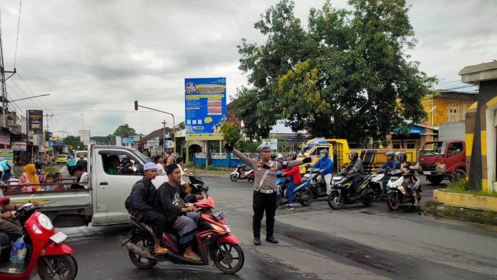 ATUR LALU LINTAS: Seorang polisi mengatur lalu lintas yang padat di ruas jalan Kediri, Jumat (21/2).