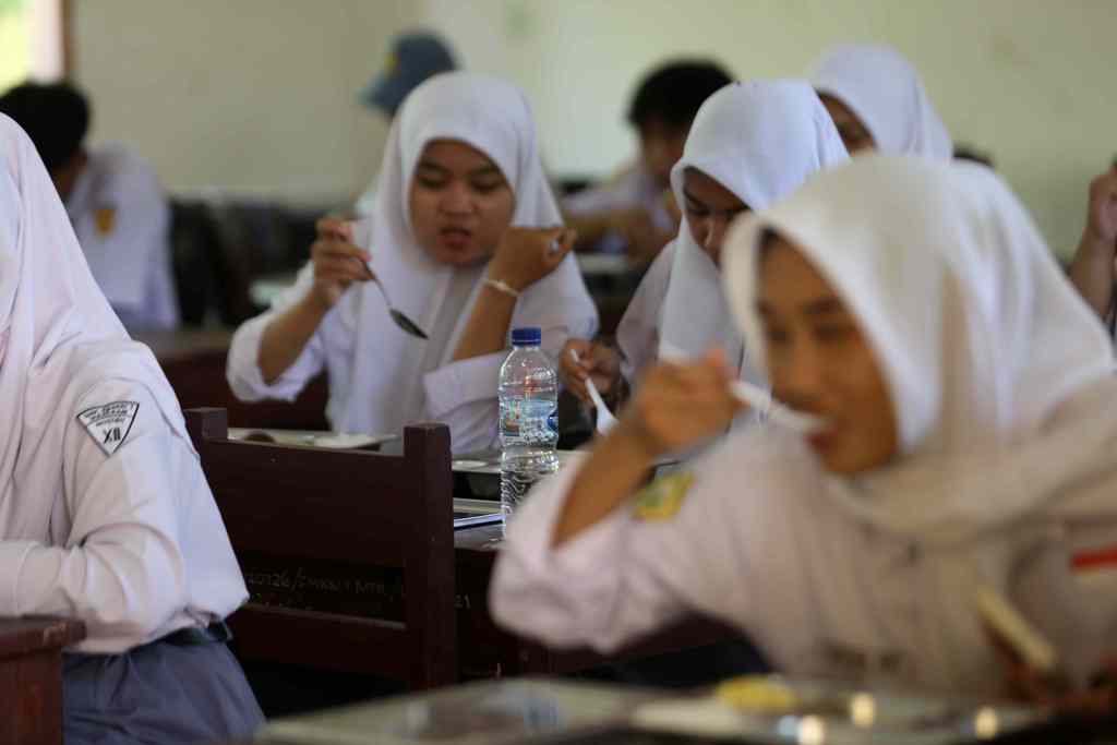 PROGRAM NASIONAL: Sejumlah siswa menyantap hindangan MBG, di salah satu sekolah di Kota Mataram. Pelaksanaan program ini harus didukung penganggaran yang cukup, tak terkecuali dari Dana Desa.