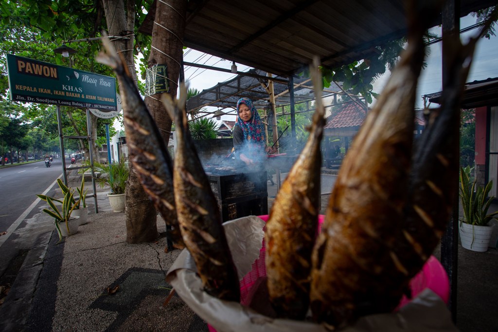 BIKIN LAPAR: Seorang pedagang ikan di kawasan Taman Loang Baloq tengah membakar ikan pesanan pembeli, kemarin (25/2). Pedagang ini merupakan definisi wirausaha yang diinginkan pemkot Mataram.