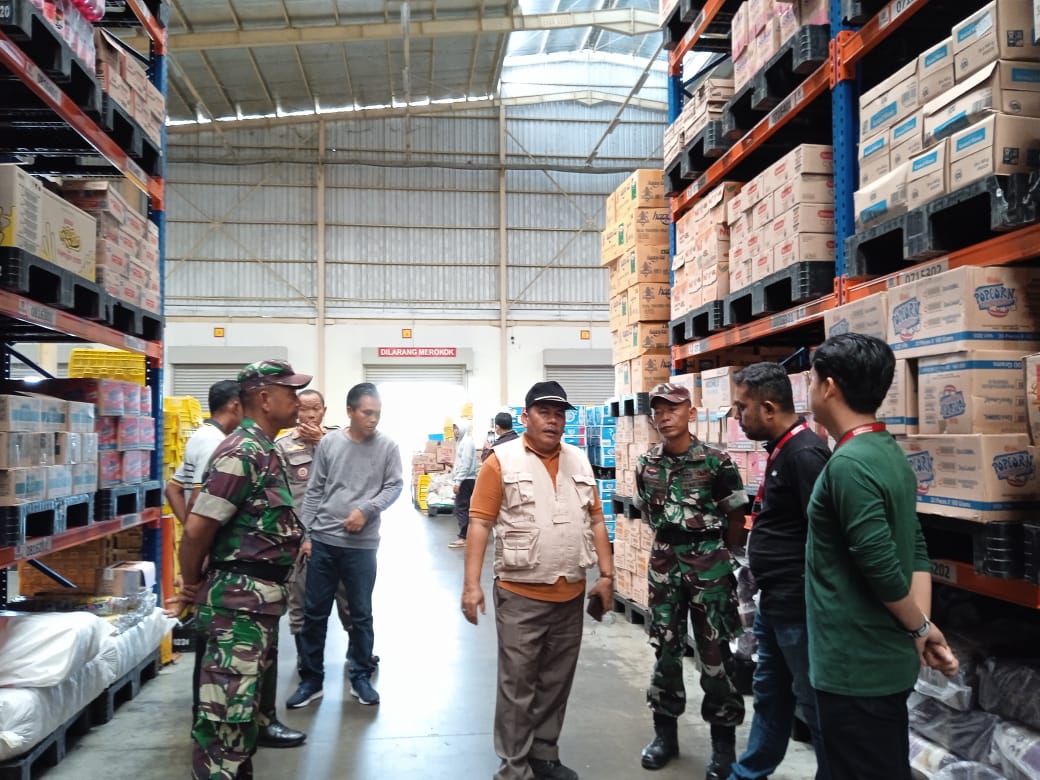 BAHAN POKOK: Kepala Disperindag Lobar Maksum (tengah) mengecek ketersediaan bahan pokok di gudang pusat Alfamart di Desan Cermen, Kota Mataram, Jumat (28/2).