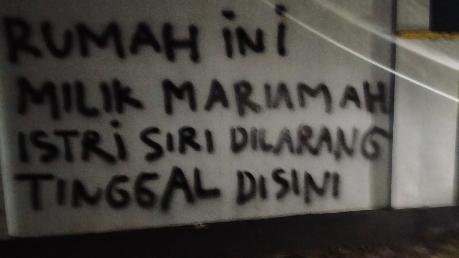 Tulisan kekecewaan yang di lampiaskan depan tembok rumah oleh Mariamah.