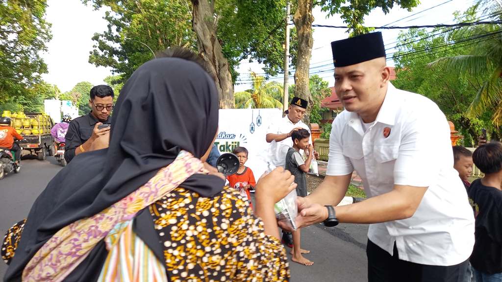 BERBAGI: Ps Kasubdit Paminal Bidpropam Polda NTB Kompol I Made Yogi Purusa Utama memberikan takjil kepada pengendara yang melintas di depan Mapolda NTB, Selasa (4/4).&nbsp;