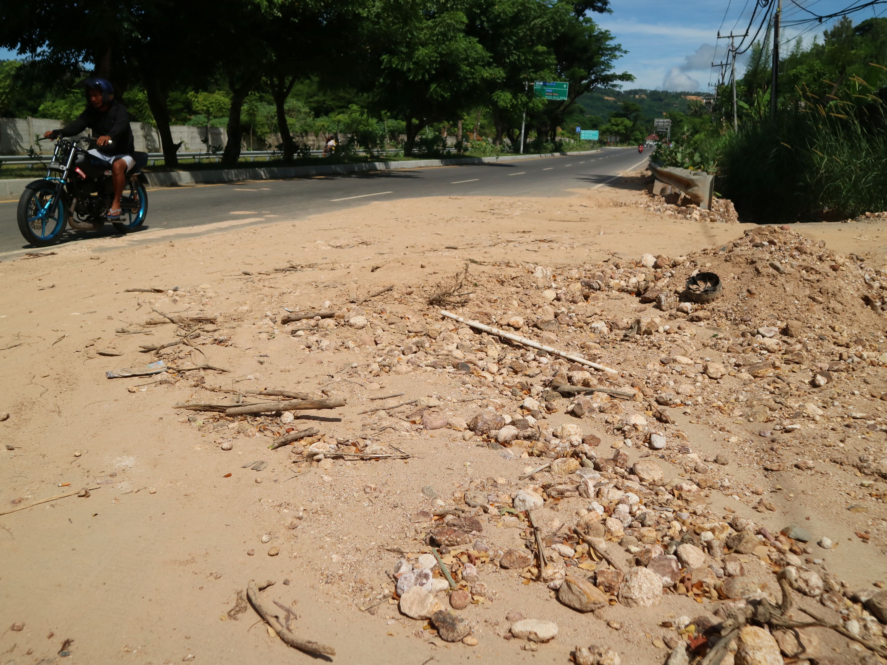 Material lumpur dan kerikil dari atas bukit turun hingga ke jalan raya ketika hujan tiba di Desa Kuta, Kecamatan Pujut, Loteng, Kamis (6/3).