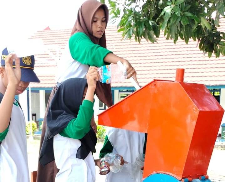 OLAH SAMPAH: Siswa SMPN 17 Mataram memasukkan sampah plastik ke mesin pencacah di halaman sekolah setempat, belum lama ini. Sampah plastik diolah menjadi paving block.
