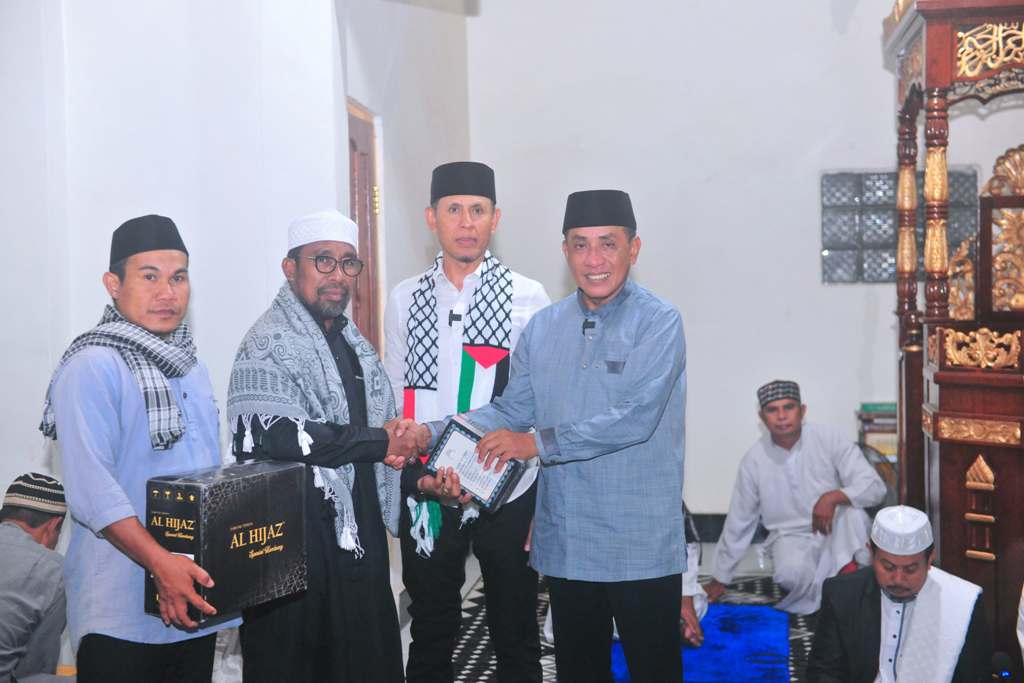 SERAHKAN BANTUAN: Bupati Bima Ady Mahyudi didampingi Wabup Bima dr Irfan menyerahkan paket Quran dan 100 sarung kepada jamaah saat safari Ramadan di Kecamatan Lambu, Minggu (9/3).