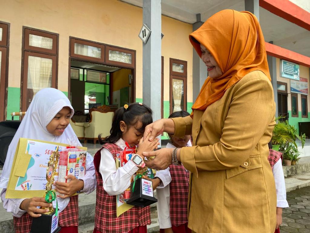 JUARA: Kepala SDN 1 Gerung Utara Sabariah memberikan piala kepada murid yang juara lomba mewarnai di sekolah setempat, Senin (10/3).