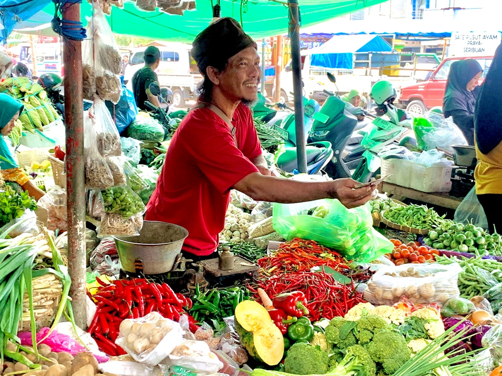 MASIH MAHAL: Seorang pedagang di pasar Kebon Roek sedang melayani pembelinya, Selasa (11/3).&nbsp;