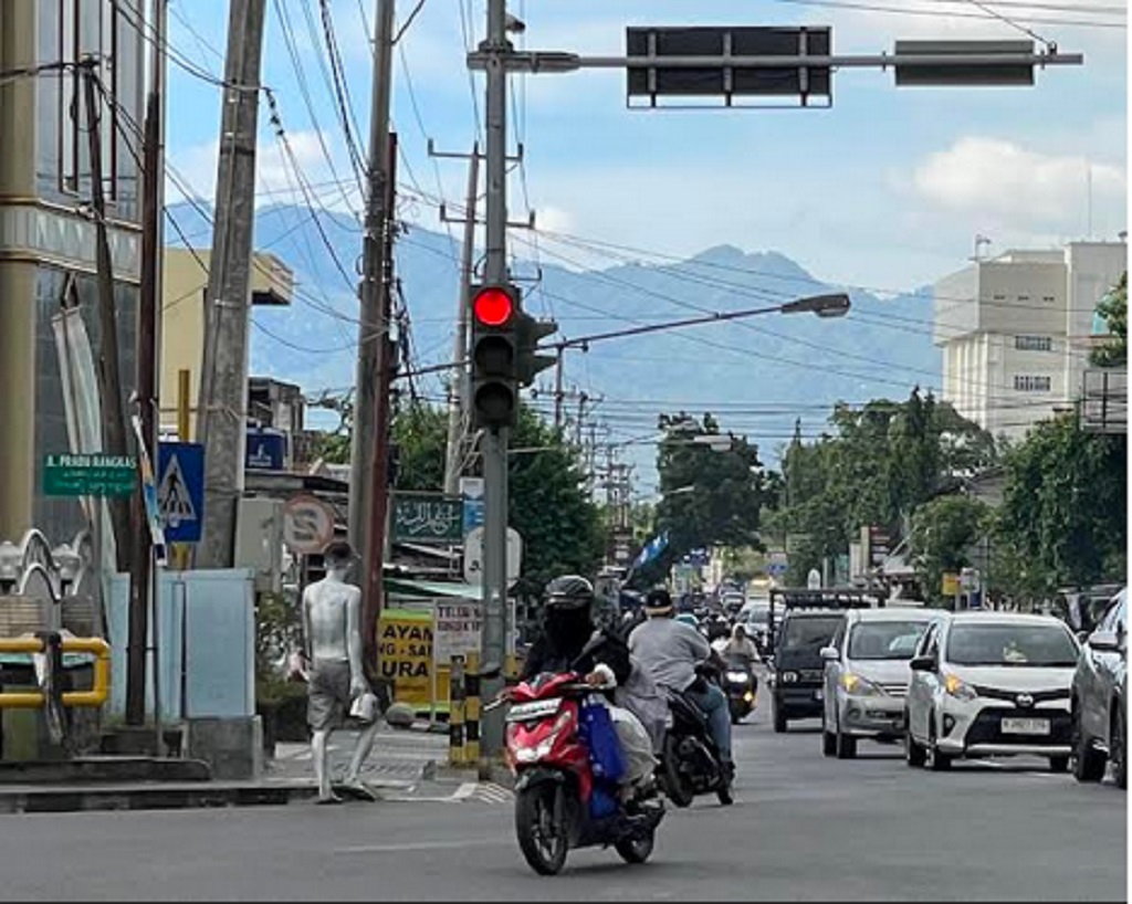 MENGHINDAR: Seorang remaja menjadi manusia silver yang tengah mengamen di simpang empat Dasan Cermen, Kota Mataram, Selasa (11/3).