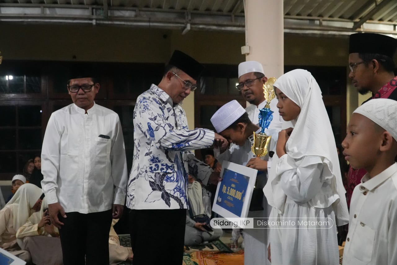 MEMBANGGAKAN: Wakil Wali Kota Mataram TGH Mujiburrahman menyerahkan uang pembinaan secara simbolis kepada Tim Tadarus Kecamatan Cakranegara yang meraih juara I tingkat SD Kota Mataram.
