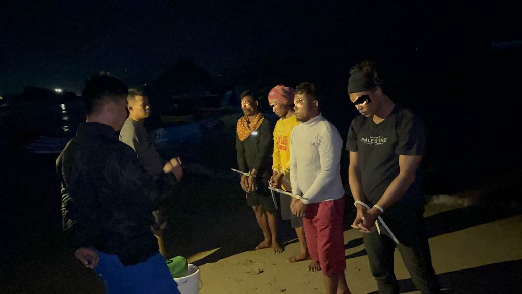 DITANGKAP: Empat nelayan yang melakukan aksi ilegal fishing diborgol polisi usai diamankan, Selasa (18/3) malam.&nbsp;