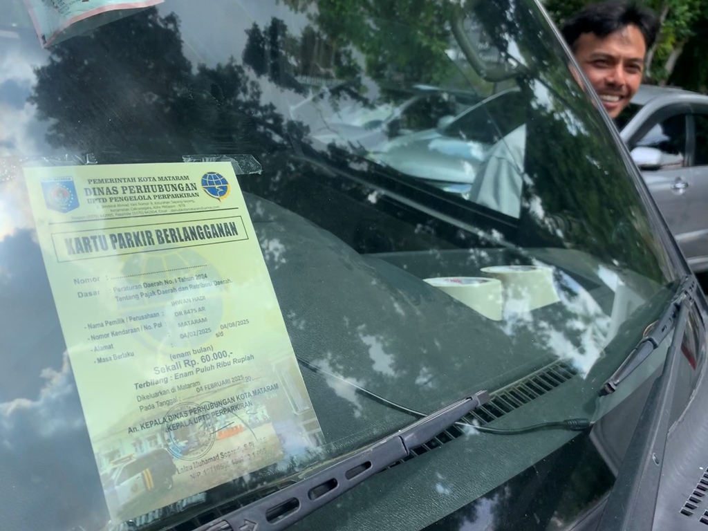 BEBAS PARKIR: Sebuah kendaraan roda empat yang ditempelkan hologram sebagai penanda berlangganan parkir di Kota Mataram.&nbsp;