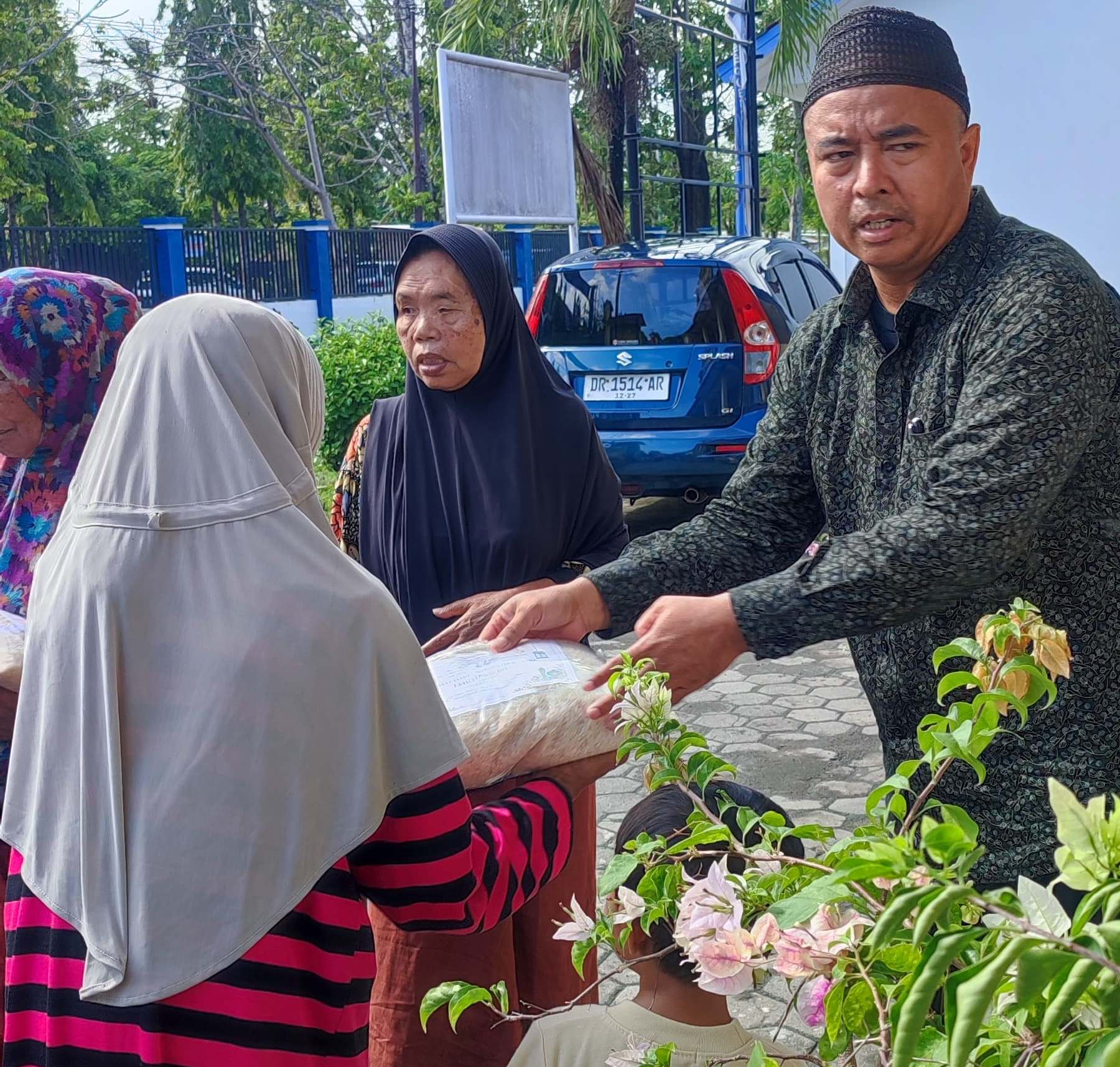 BERBAGI: Guru SMPN 17 Mataram membagikan sembako kepada warga sekitar sekolah, pekan lalu.