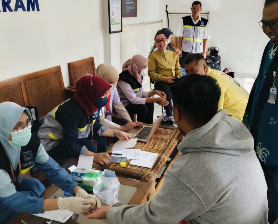 SENYUM: Kepala Dinas Kesehatan Kota Mataram dr. H. Emirald Isfihan, MARS., MH., CMC., FISQua, saat memantau pemeriksaan kesehatan sopir bus, Selasa (25/3).