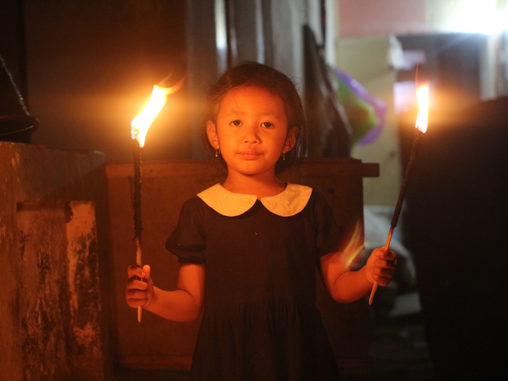 NYALAKAN: Dua Orang anak di Lombok Timur (Lotim) saat menyalakan obor kecil atau dila Jojor&nbsp; pada malam ke 25 bukan ramadan, Senin (24/3).