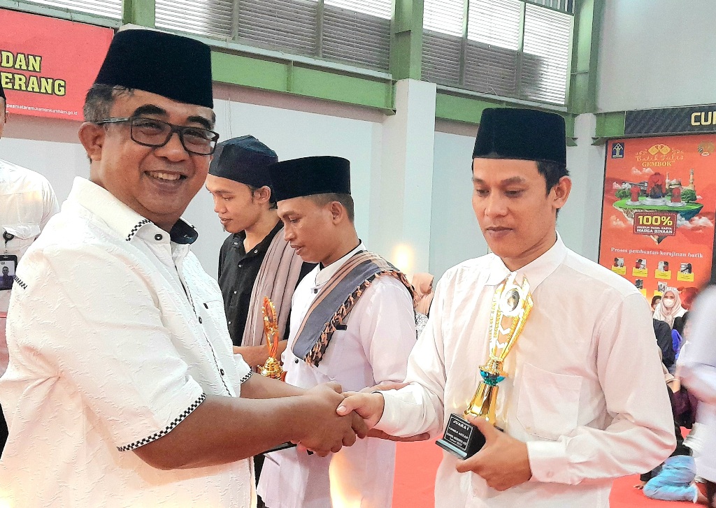 NAPI BEPRESTASI: Ahmad Fauzi (kanan) warga binaan Lapas Kelas IIA Lobar yang berhasil juara I Lomba adzan antar Lapas dan rutan se-NTB saat menerima piala dari Kakanwil Ditjenpas NTB Anak Agung Gede K