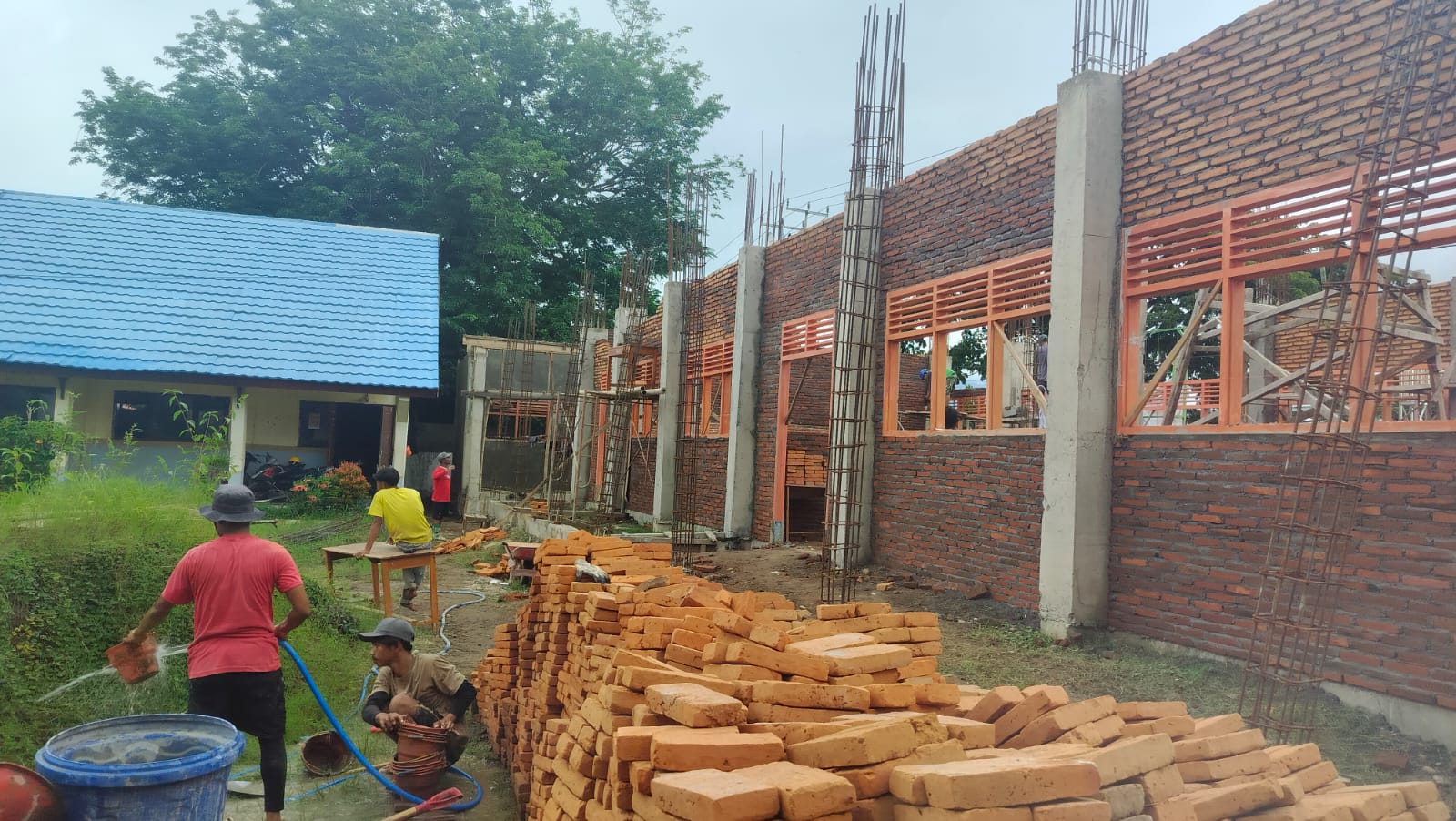 Para tukang sedang menyiapkan bata untuk pemasangan tembok SMAN 2 Bolo, Kabupaten Bima, beberapa waktu lalu. (Muhammad Aminurlah For Lombok Post)