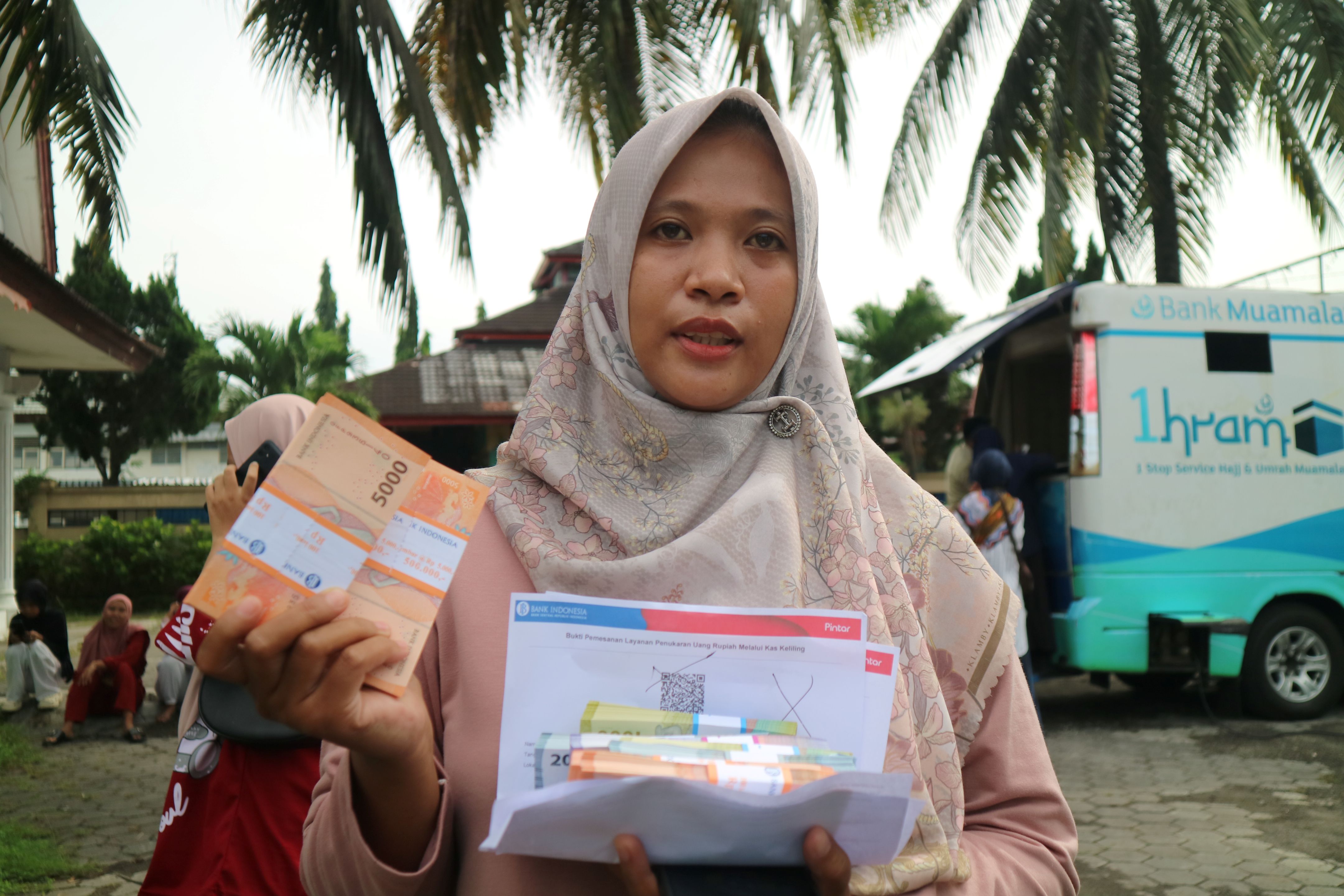 Aldiyanti menunjukkan sejumlah uang pecahan baru yang ditukarkan melalui Kas Keliling di halaman Kemenag Loteng, Kamis (27/3).