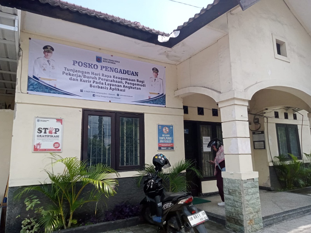 BUKA PENGADUAN: Seorang sedang berdiri di depan Posko Pengaduan Disnaker Kota Mataram beberapa waktu lalu.&nbsp;