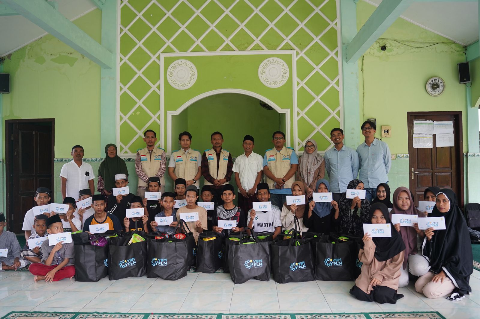 Pengurus YBM PLN UIP Nusra bersama para mustahik, usai penyaluran bantuan, Senin (24/3).