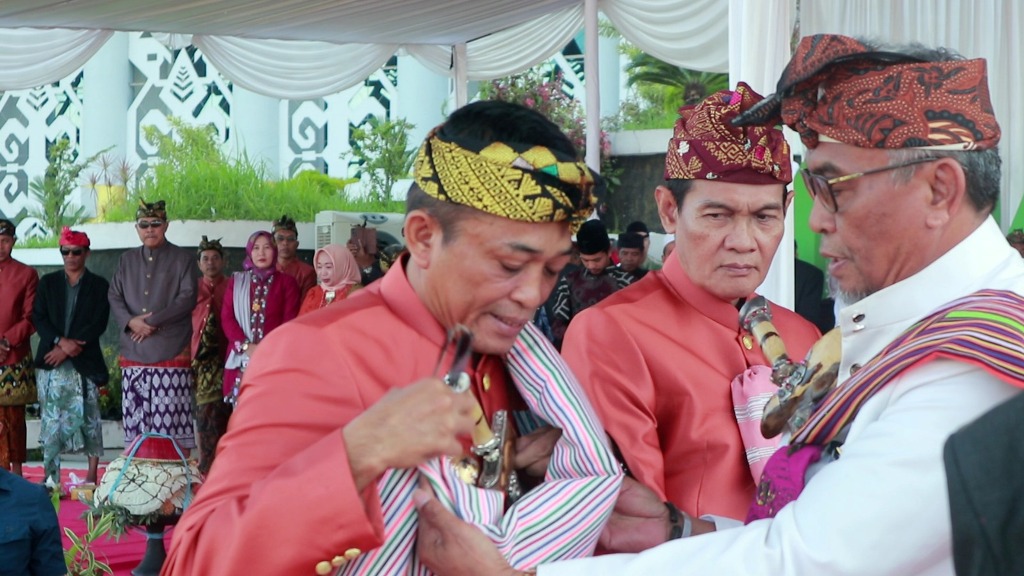 BENTUK KEHORMATAN: Bupati Loteng Lalu Pathul Bahri dan Wabup Loteng HM Nursiah diangerahi gelar Pengerakse Gumi Tastura oleh para tokoh adat pada perayaan Lebaran Topat, Senin (7/4).
