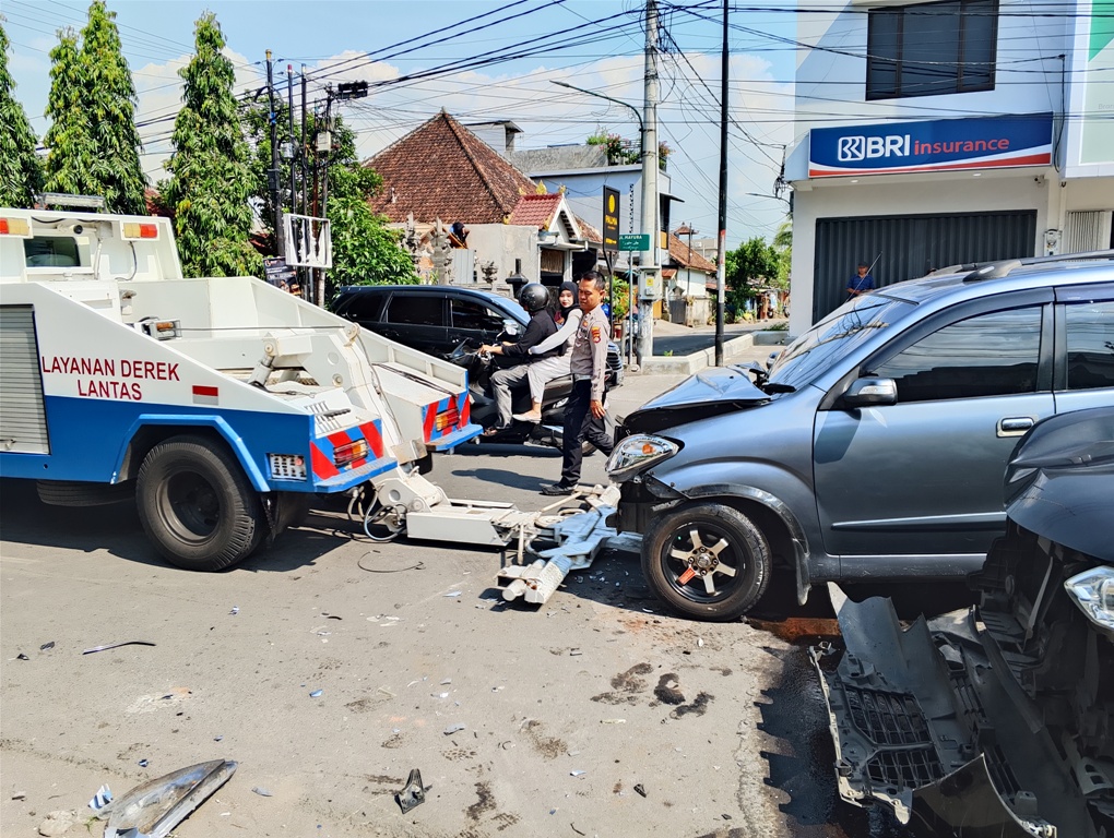 OLAH TKP: Anggota Satlantas Polresta Mataram menderek mobil yang tabrakan beruntun di Jalan Sriwijaya, Cakranegara, Mataram, Senin (7/4).&nbsp;