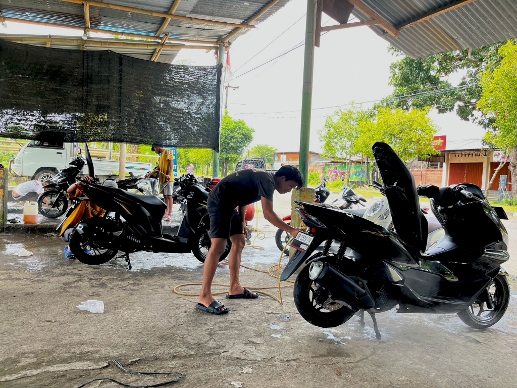 USAHA CUCI KENDARAAN: Salah satu rekan Aldis yang tengah mencuci kendaraan konsumen, Senin (7/4).