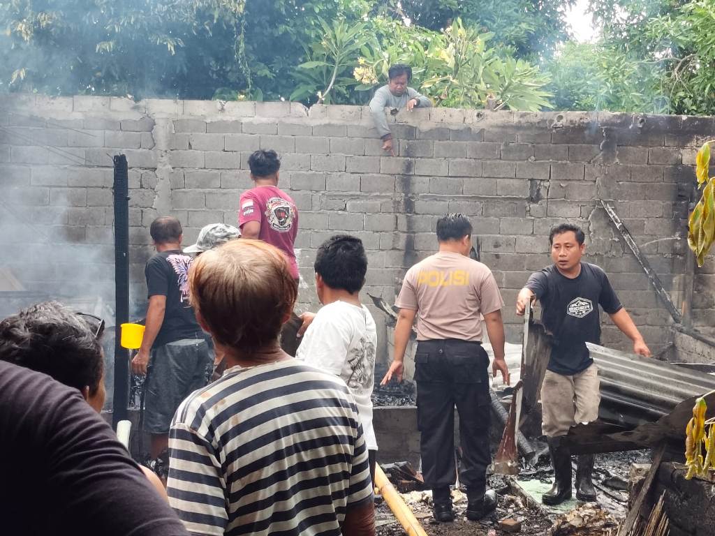 PADAMKAN API: Sejumlah anggota Polsek Mataram bersama warga berupaya memadamkan api saat peristiwa kebakaran terjadi di Lingkungan Pekendalan, Pagesangan, Mataram, Selasa (8/4).&nbsp;