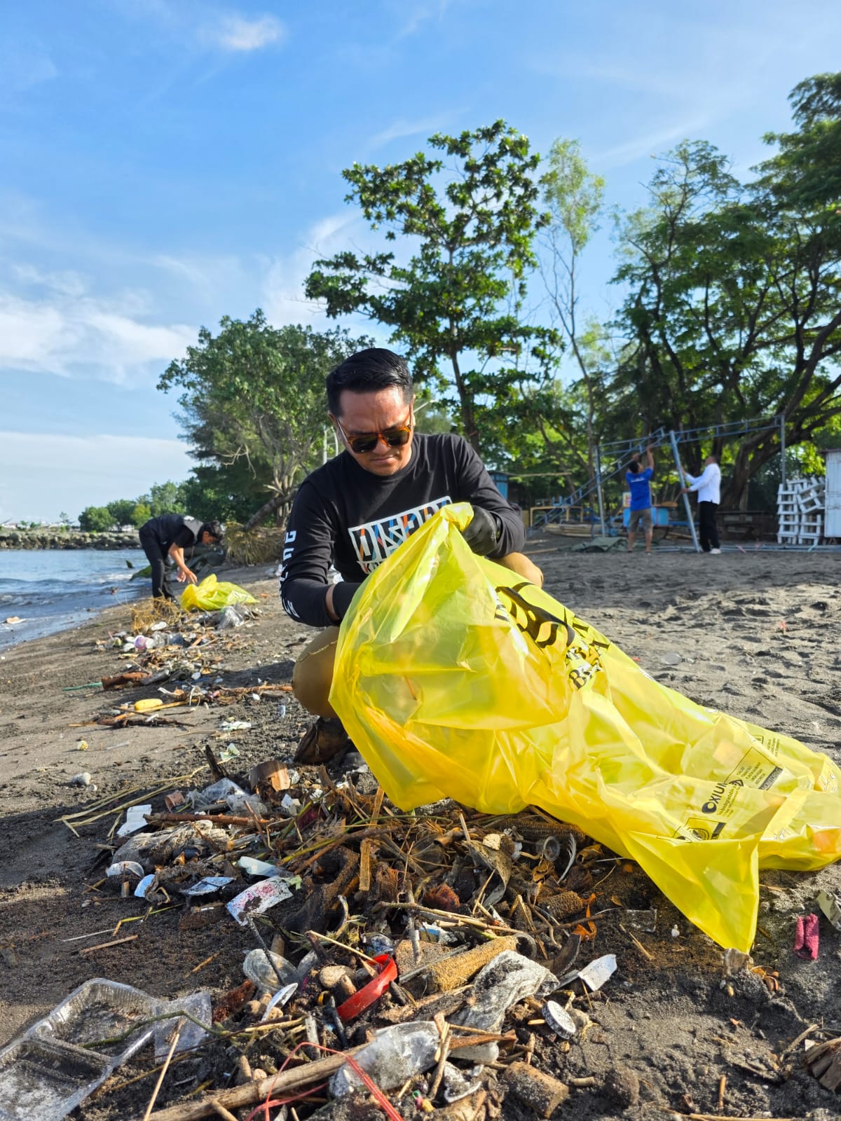 TERJUN LANGSUNG: Kepala Dinas Pariwisata Kota Mataram Cahya Samudra memungut sampah di Pantai Loang Baloq, Senin (14/4/2025).
