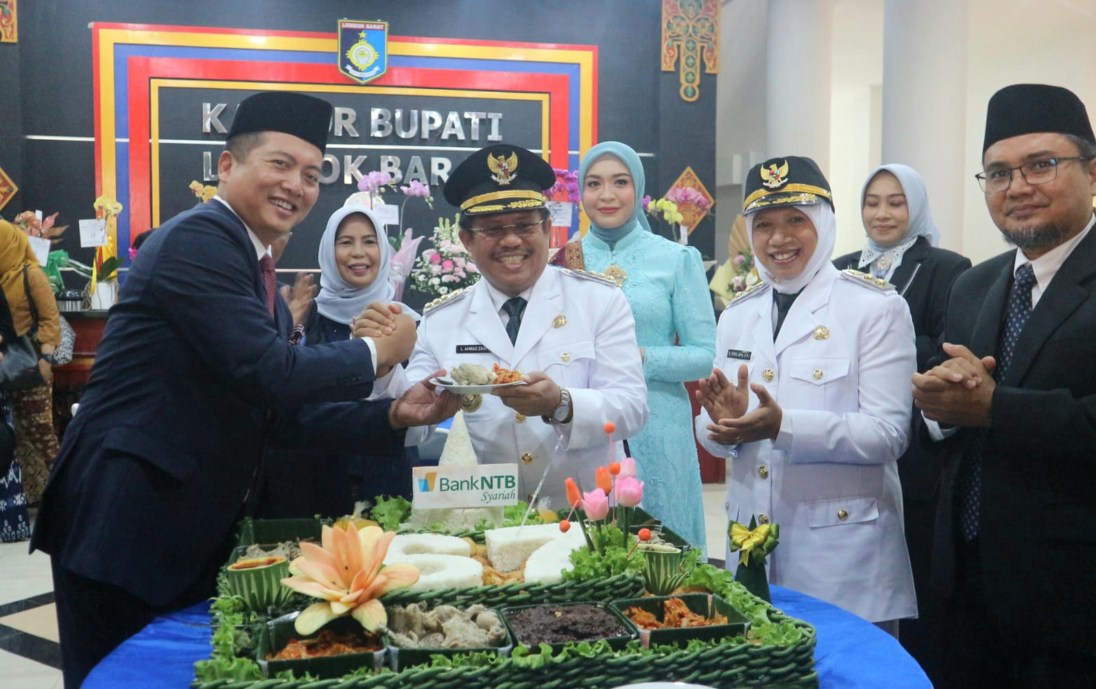 Gubernur NTB Lalu Moh Iqbal menyerahkan tumpeng ke Bupati Lobar Lalu Ahmad Zaini dan Wakil Bupati Lobar Nurul Adha dalam perayaan HUT Lobar ke-67, Kamis (17/4).